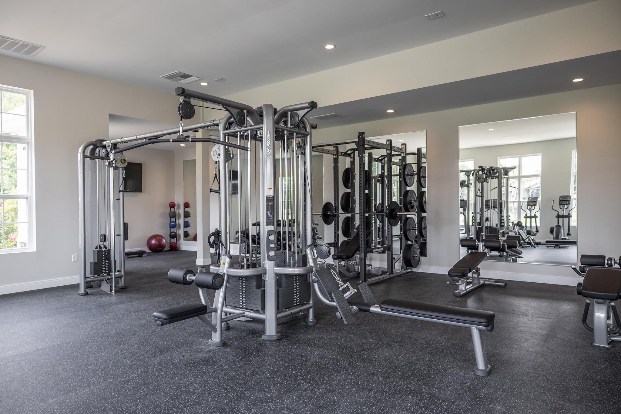 a gym with weights and cardio equipment in a building